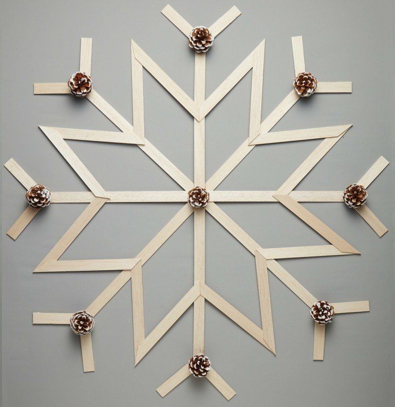 Hantverkspinnar av trä och små kottar för en snöflinga