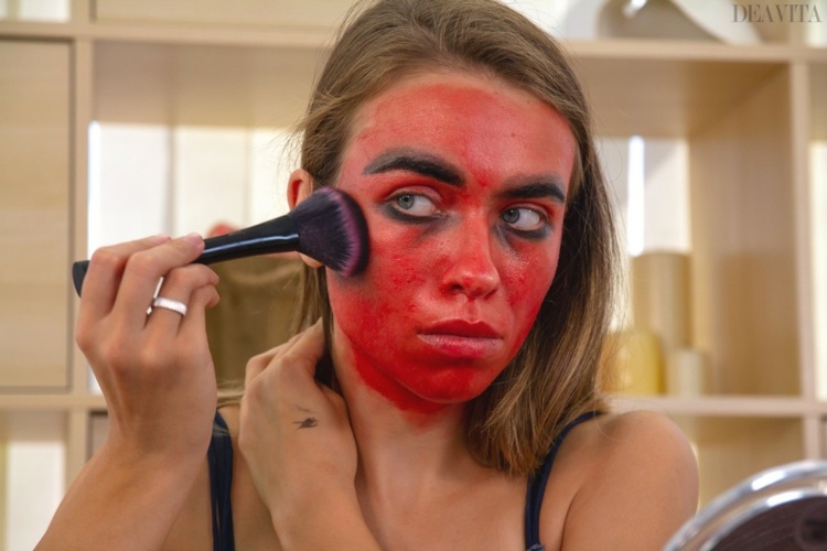 applicera röd ansiktsfärg demon make-up halloween gör ögonbrynen tjockare