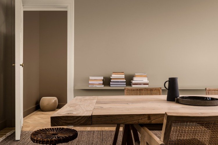 rustikt matbord i minimalistiskt vardagsrum med väggar målade i dulux enfärgad modig mark