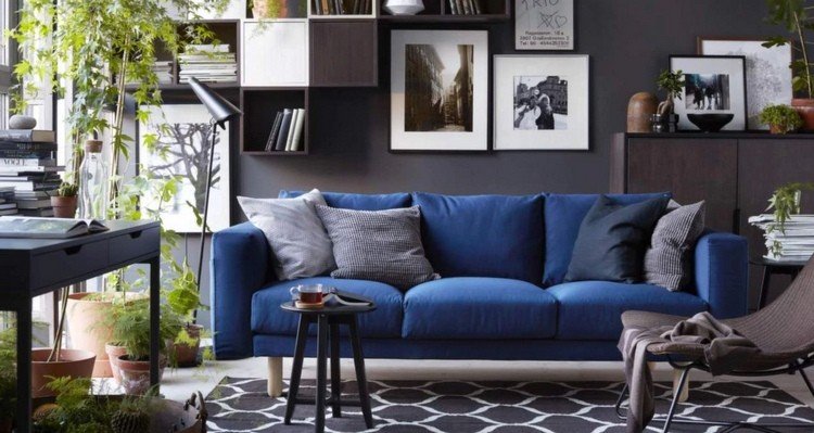 mörkblå soffa framför en grå vägg