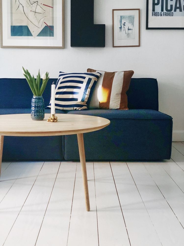 blå soffa skandinavisk med vita väggar och vitt plankgolv
