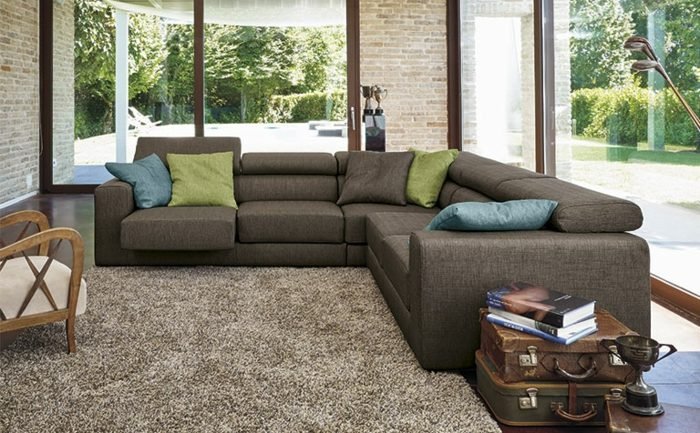 modernt-hörn-soffa-med-klädsel-tegel-vägg-hus
