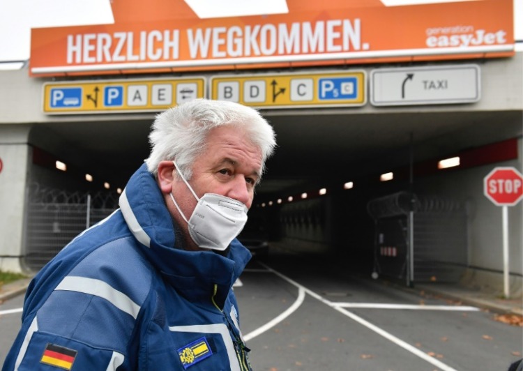 ex -chefen för brandkåren albrecht broemme står på tegel flygplats med en skyddande mask