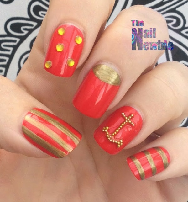 röda naglar med guldfärgade accenter och ankare