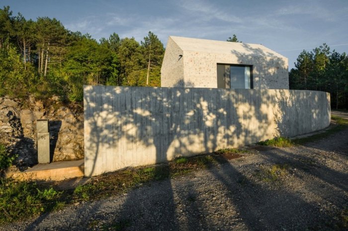 husdesign i Slovenien mark betongmur sten skog