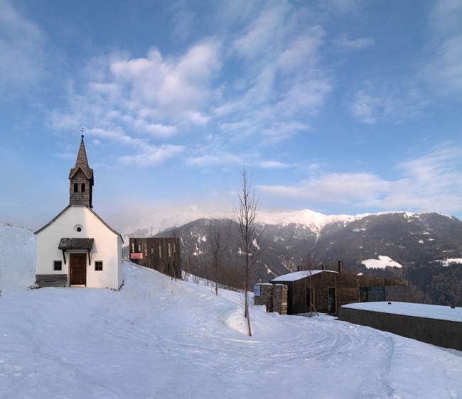 modernt fritidshus omgivning snöiga kullar italien burgmeisterwolf