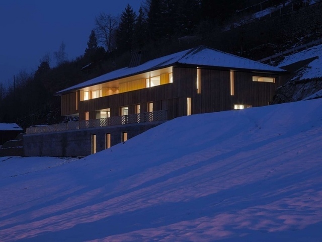 modernt fritidshus snöiga kullar nattbelysning fribourg schweiziska alperna
