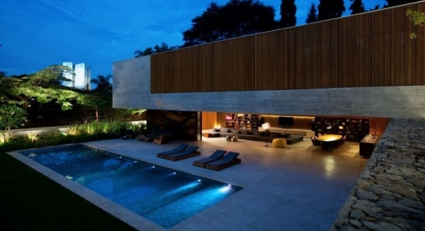 Hus gjord av exponerad betong platt tak trä fasad