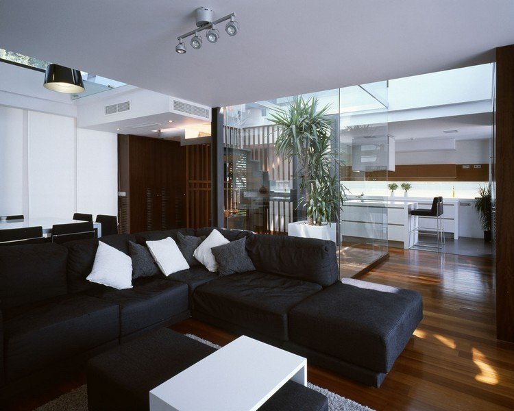 modernt-vardagsrum-soffa-svart-mörkt-planka-golv-vitt-soffbord