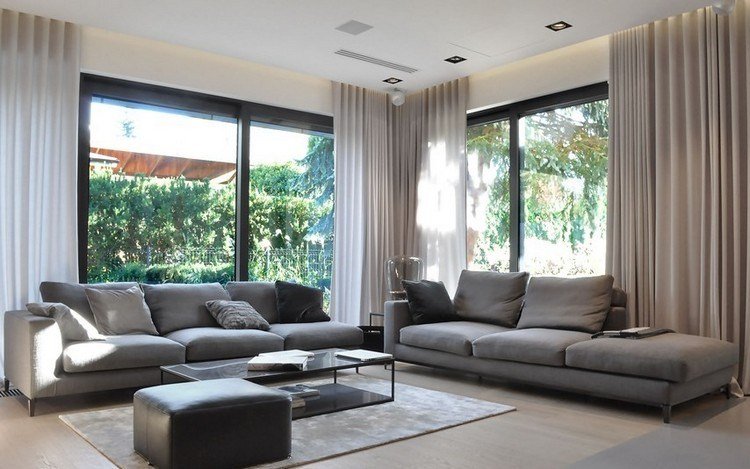 modernt vardagsrum-soffa-grått-ljusare trägolv-soffbord-grädde-gardiner