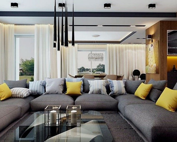 modernt vardagsrum-soffa-grå-gul-kuddar-glas-soffbord-svart-hängande lampor