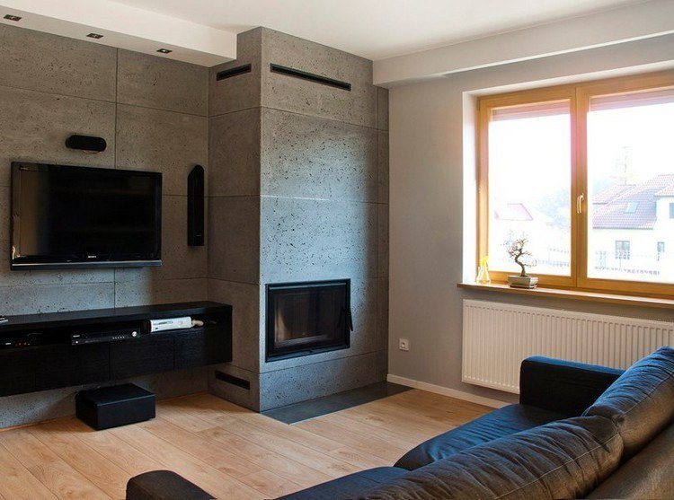 modernt vardagsrum-soffa-mörkgrå-öppen spis-väggpaneler-betong-look