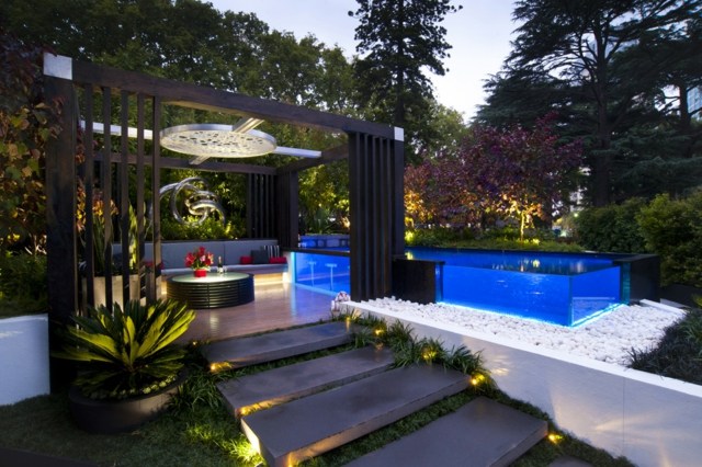 Kvällsträdgård stor pool sittgrupp fin design