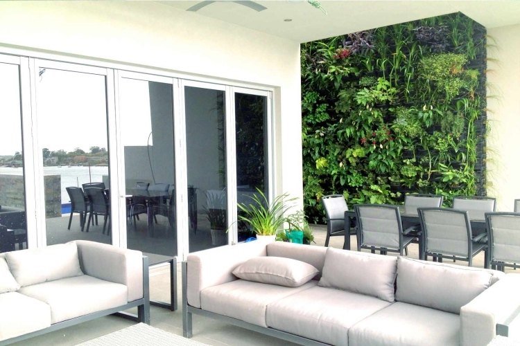Vertikal trädgård-soffor-ljusgrå-klädsel-matbord-stolar-modern-enkel-terrass-dörrar