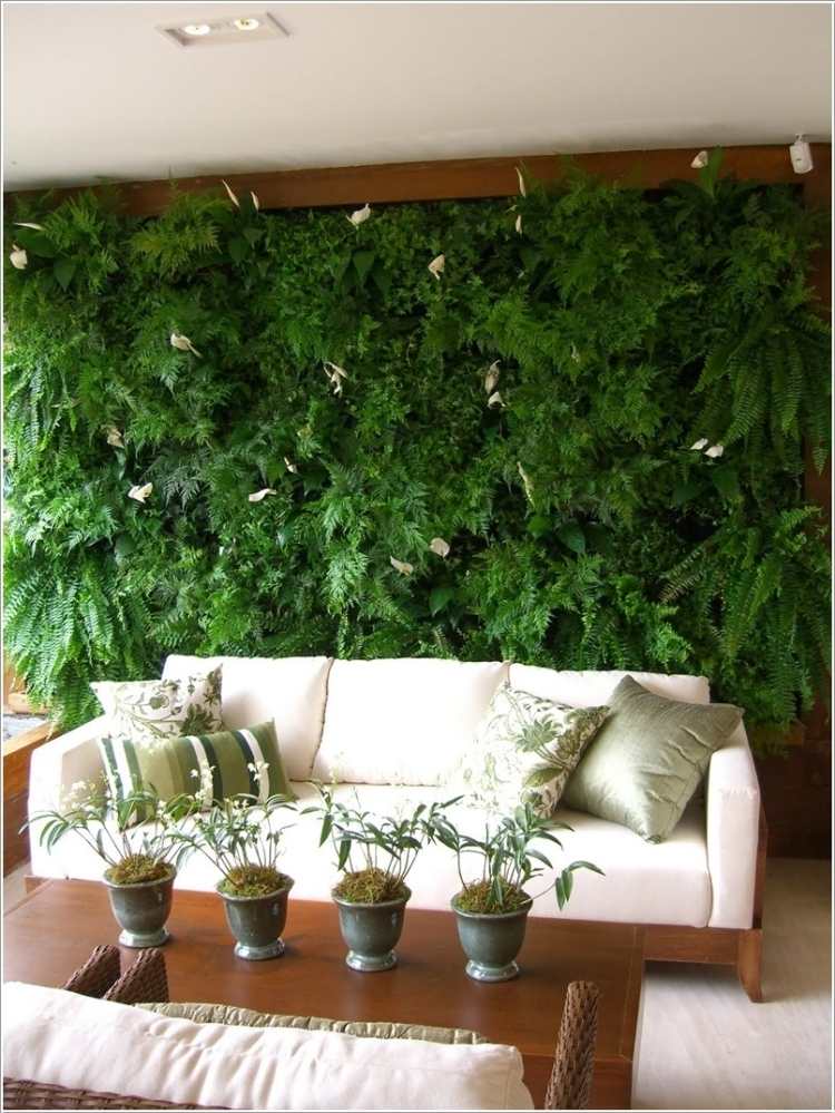 vertikal-trädgård-vardagsrum-soffa-trä-soffbord-kuddar-grönaktiga-fläckar-växter