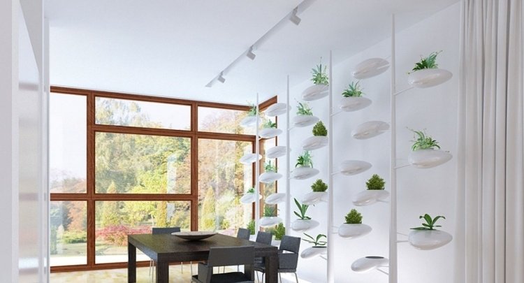 vertikal-trädgård-ultramodern-matsal-vit-matbord-stolar-svart-fönster-spotlights