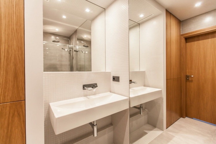 Modernt badrum med vit mosaik och inbyggda skåp