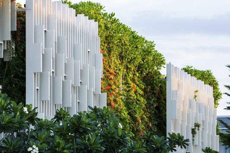 Innovativ grön fasad i kombination med vita rutnätpaneler som ventilationssystem
