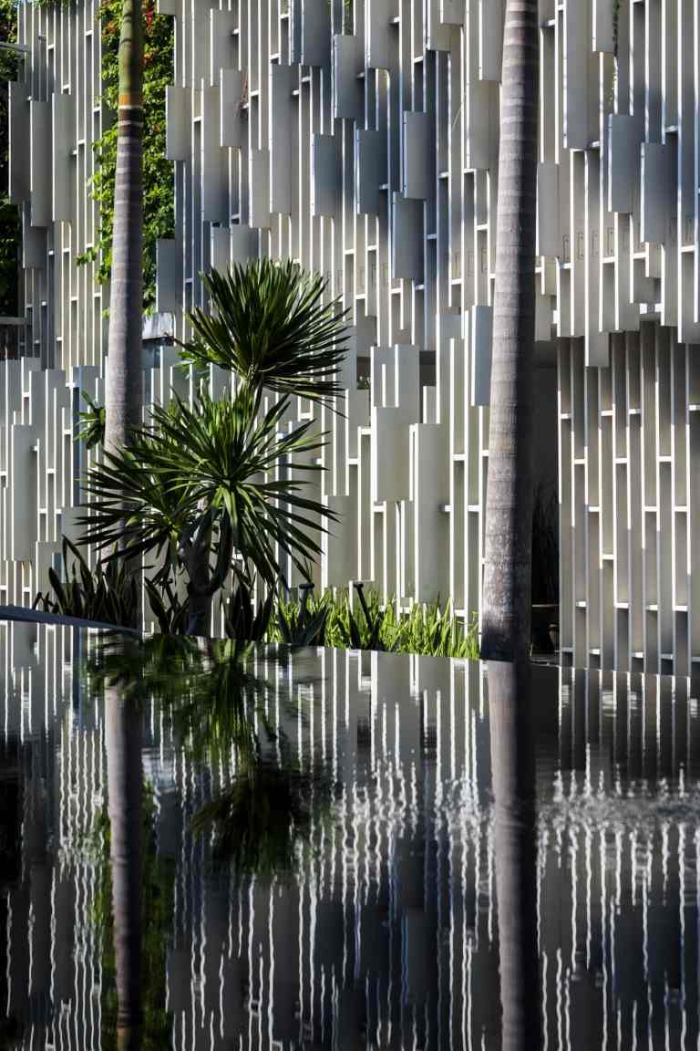 Det yttre området runt byggnaden liknar en oas med damm och palmer
