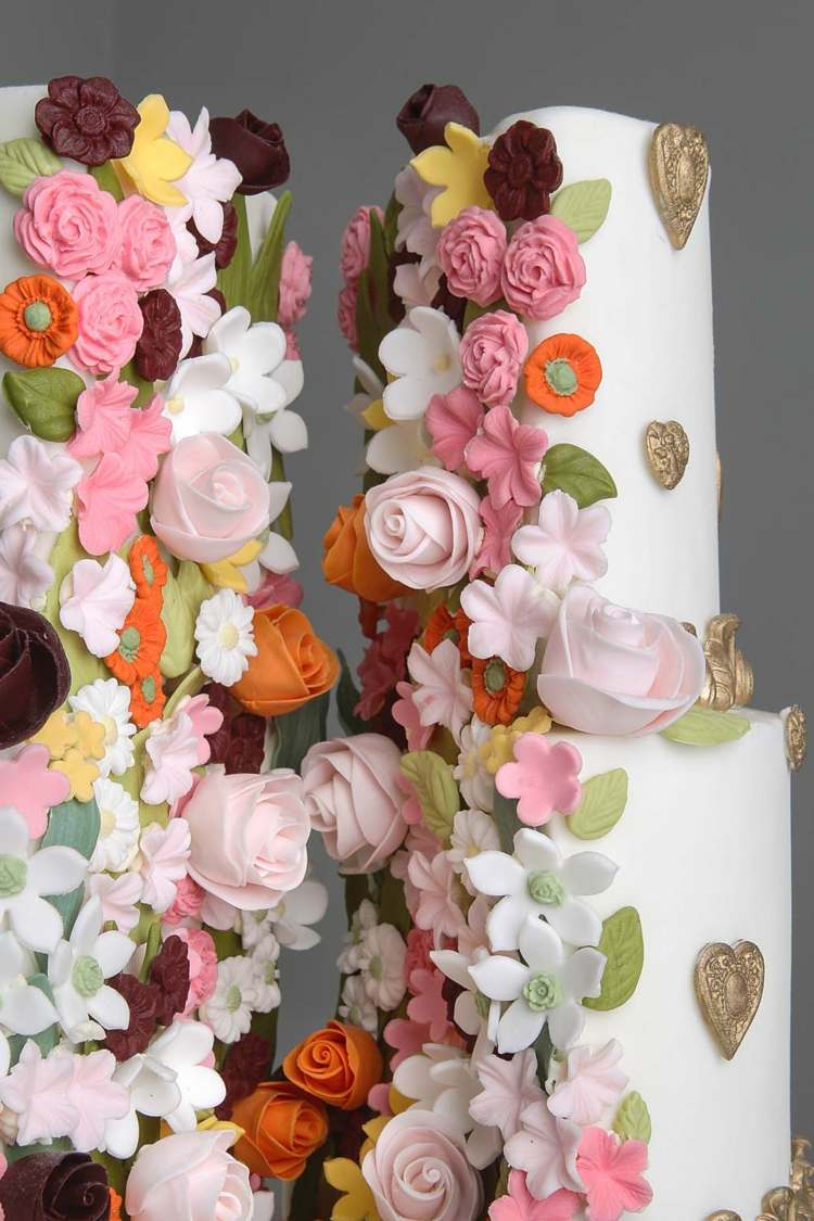 En annorlunda delad bröllopstårta med massor av ätliga blommor gjorda av socker