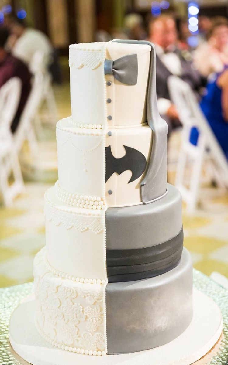 Bruden och brudgummen poserar med Batman med bröllopstårtan