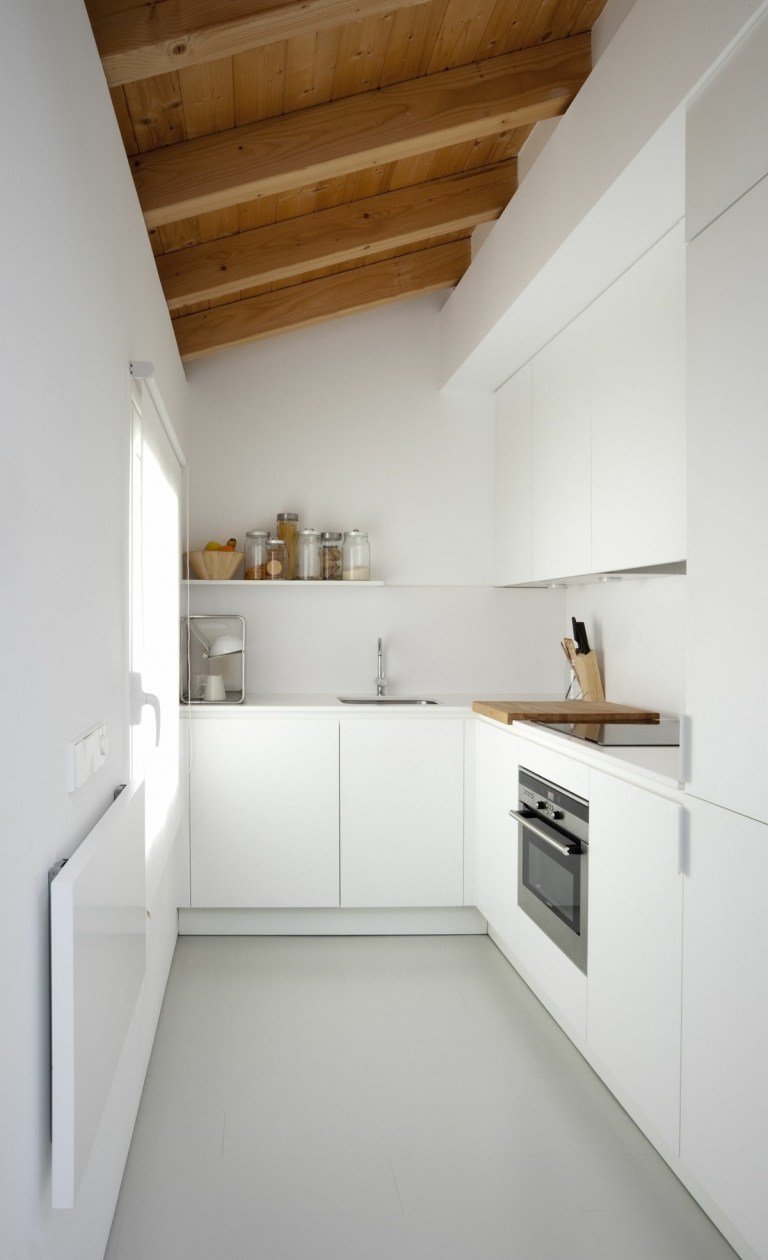 Smalt kök i minimalistisk stil med sluttande tak och balkar