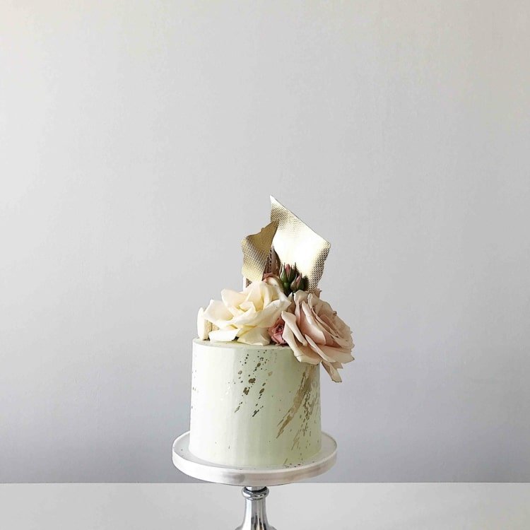 Liten kakdesign med en överdådig tårtdekoration med rosor