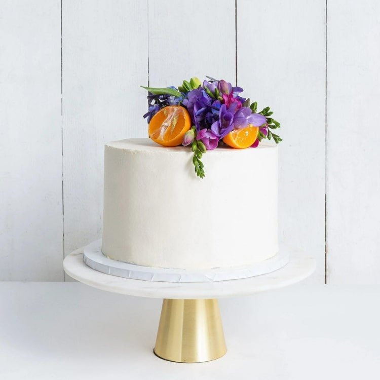 Exotisk tårtdekoration med apelsiner och lila orkidéer