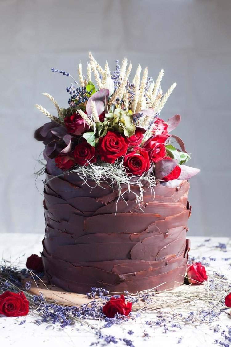 Enkla små bröllopstårtor på en nivå med choklad och röda rosor