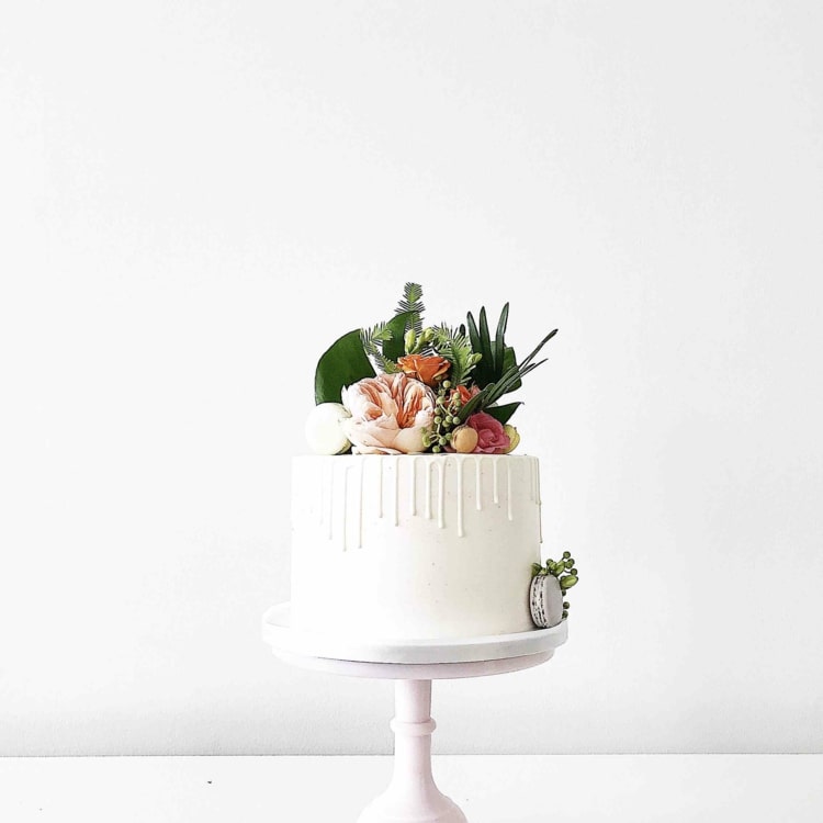 Enkla små bröllopstårtor på en nivå - droppkaka i vitt med exotiska blommor