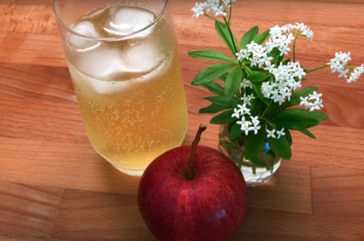 Alkoholfri stans med äppeljuice och woodruff-blommor