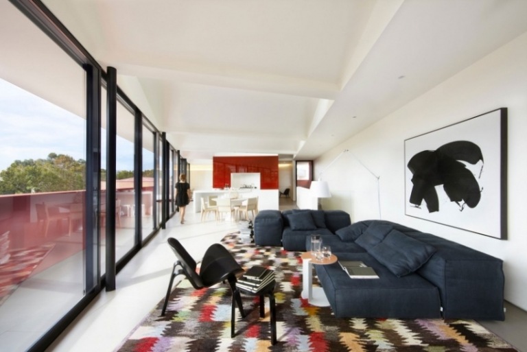 Möbler för vardagsrummet -vit-soffa-mörkblå-matta-färgstark fönstervägg