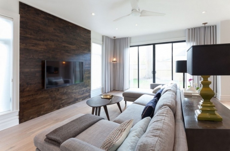 Inredning-vardagsrum-soffa-stor-grå-TV-väggbeklädnad-trä-mörkt terrassfönster