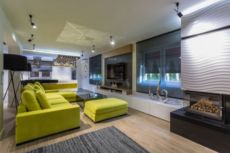 Inredning-vardagsrum-senap-gul-soffa-klädsel-öppen spis-tv-vägg-belysning-matta-grå