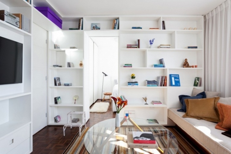 Möbler till vardagsrummet - vit vägghylla - matta - soffbord - glas - tv - kudde - bänk