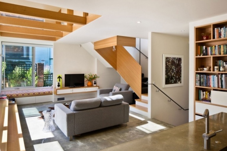 möblering-vardagsrum-soffa-grå-golv-trappor-balk-trä-bänk-fönster