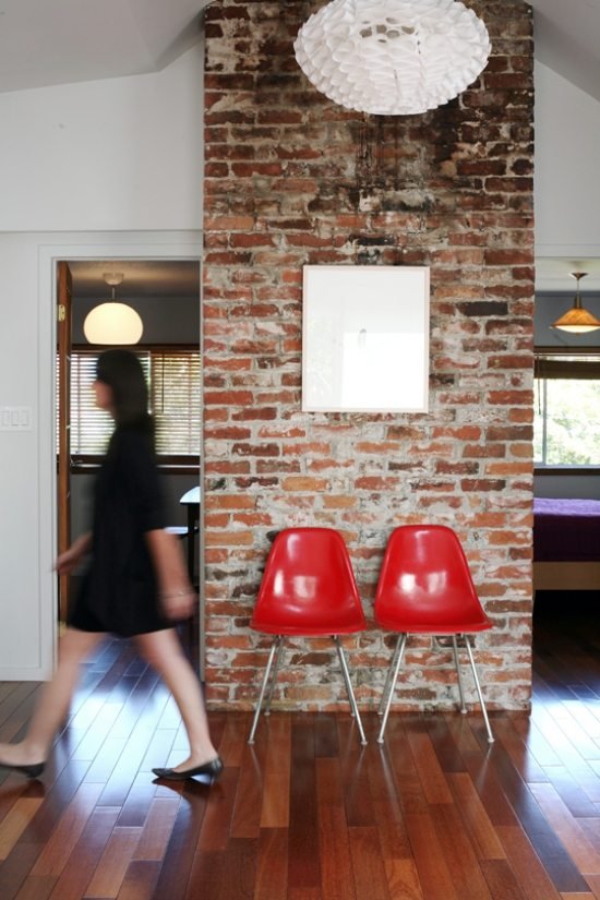 Tegelvägg inredning-röda stolar-trägolv-liten lägenhet uppsatt