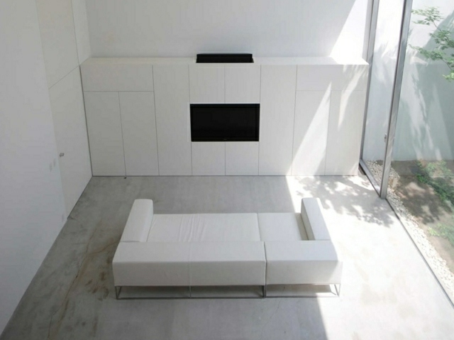 Vardagsrum inrättad vit soffa djup sits vägghylla högglansiga fronter