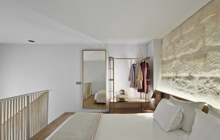 Hamprep-räcke-sov-område-säng-kuddar-sten-vägg-vit-spegel-galgar-brons-ram-kläder