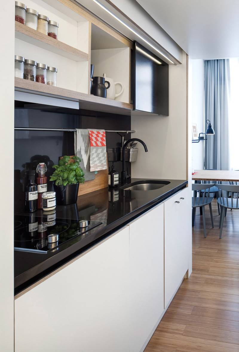 Design ett-rumslägenhet -funktionalitet-kök-kök rad-dold-svart-vit-vanlig-kokplatta-diskbänk
