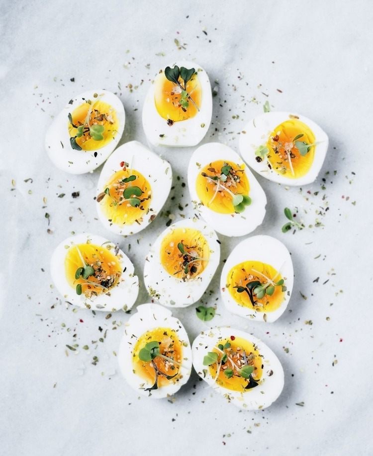 Halvera proteinhaltiga livsmedel som kokta ägg och krydda dem som goda mellanmål mellan måltiderna