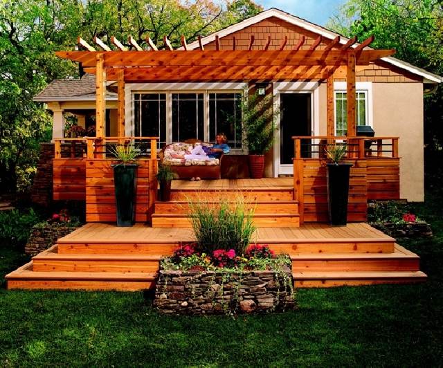 Trähus pergola veranda med lounge möbler prydnads gräsmatta trädgård