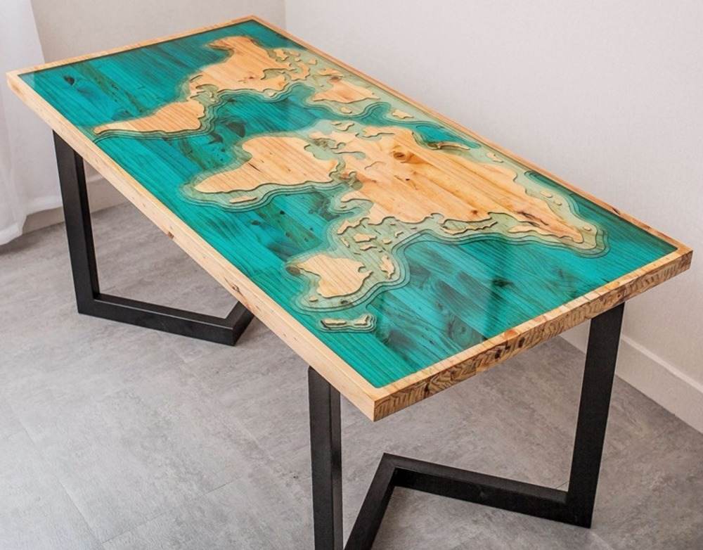 världskarta avbildad på epoxihartsbord med trä och ben av svart metall