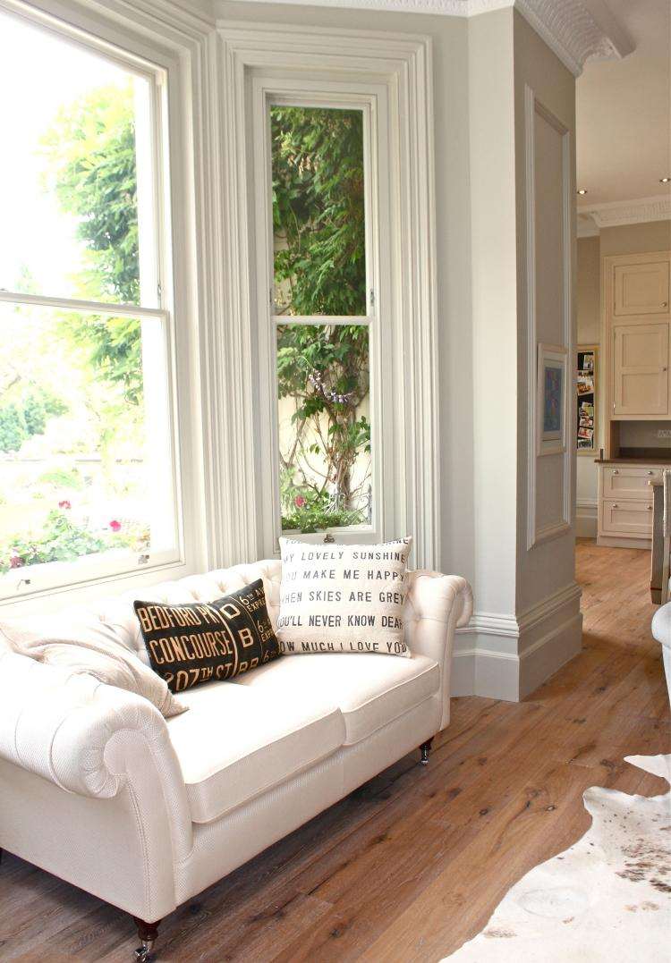 Fönster-dekorera-soffa-vit-stuckatur-trä-golv-päls-matta-dynor