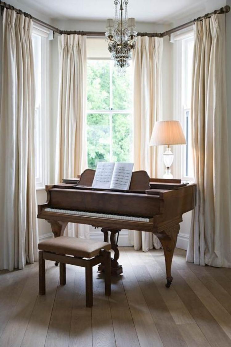 Fönster-dekorera-golvbräda-piano-vita-gardiner-ljuskrona-bordslampa