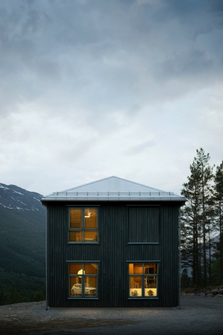 Klassiskt skandinaviskt hus med träpaneler och rektangulära fönster