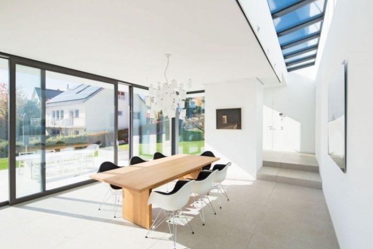 matsal-möbler-vita-stolar-plast-matbord-massivt trä-vägg-tak-fönster-glas vägg-trädgård-view