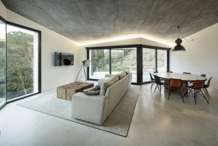 matsal-möbler-grå-indirekt-belysning-soffa-matbord-runda-stolar-glas-vägg-fönster