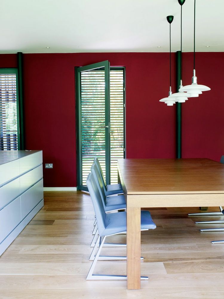 matsal i röda mörkgröna fönsterkarmar-accenter-matbord-trä-ljusblå-stolar