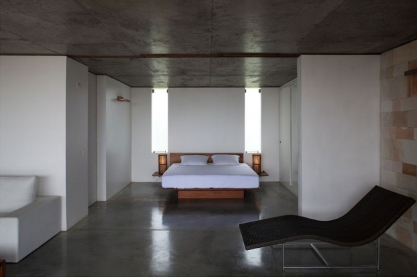 Puristiskt sovrum med enkel vit väggbelysning